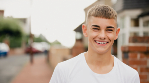 Young man archie smiling on a street