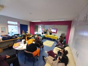 A room full of residents sat on chairs looking at the food demonstration at the front of the room
