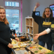 Resident and harvest staff smiling as they make bruschetta