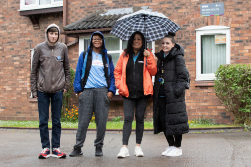 myth busting: two young men and two members of staff smiling stood outside a building. One woman holding an umbrella