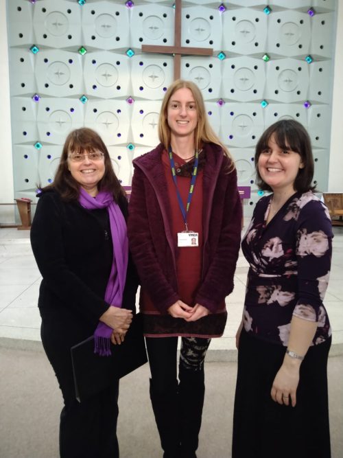 songbirds choir: three women standing smiling in a church.