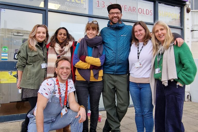Matt, business owner of Big Hug Brewing, stood outside Brighton Youth Advice Centre with six member of staff smiling