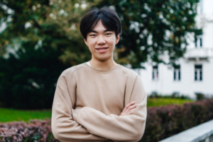 Leo, who was supported by family mediation, smiling and crossing his arms wearing a beige jumper