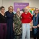 five women standing together and smiling at ymca downslink group event for world mental health day and world homelessness day