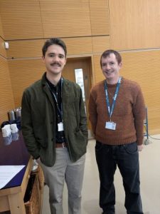 two men standing and smiling at the camera