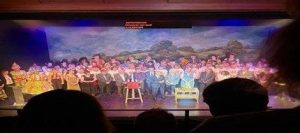 view from the audience of a crowded theatre stage