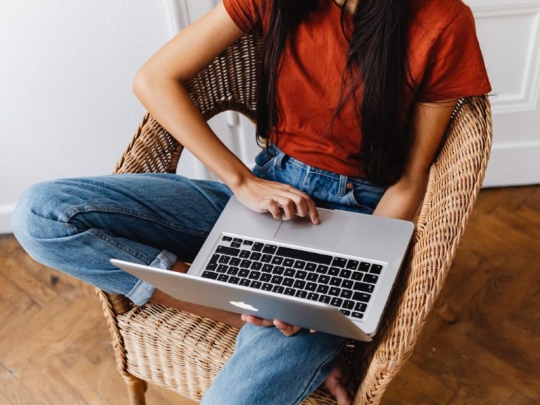 young woman on laptop, head not visible