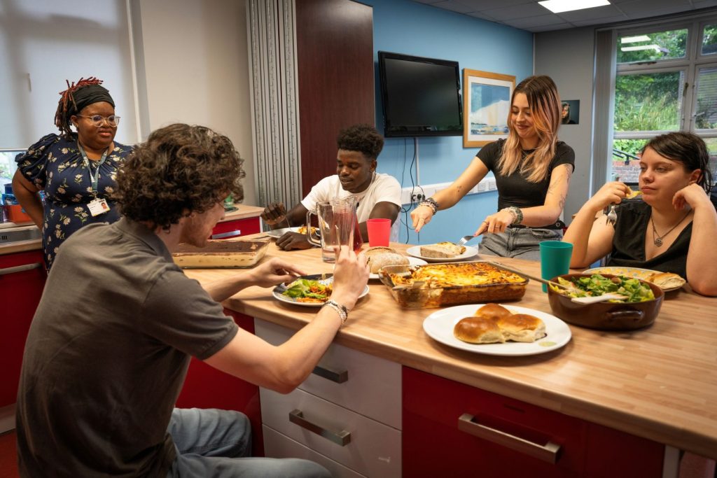 adult and young people gathered around a table loaded with dishes