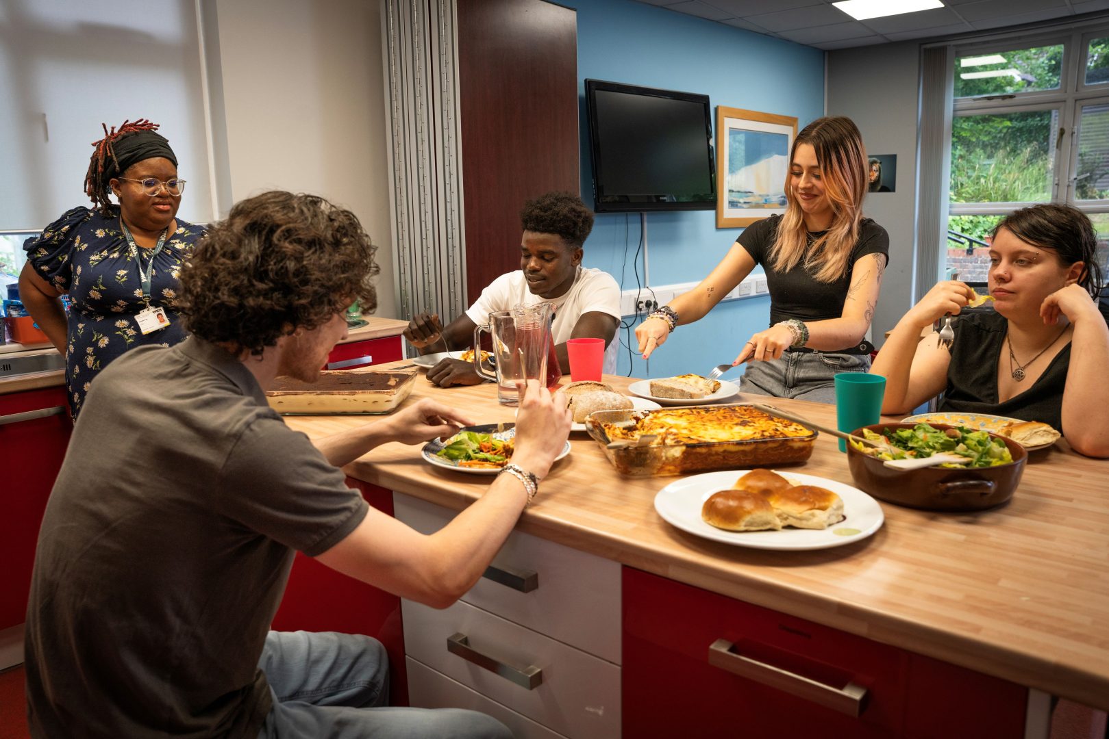adult and young people gathered around a table loaded with dishes