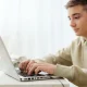 male teen on laptop wearing headset