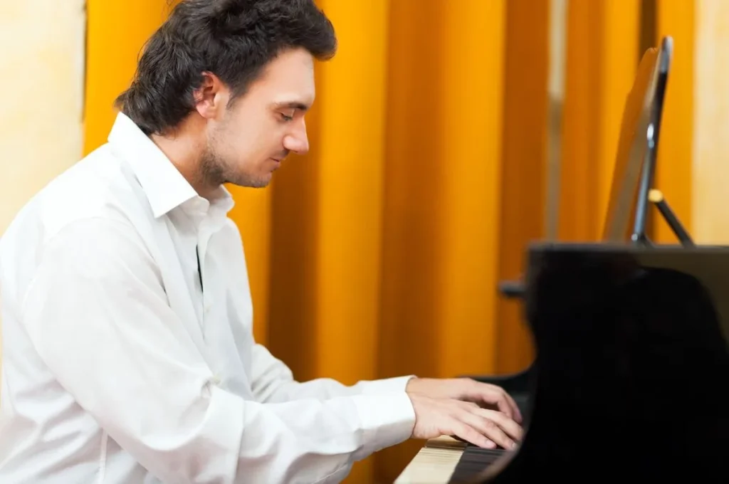young man playing the piano in profile