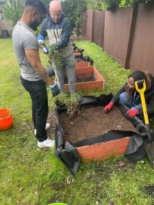 two men and a woman gardening