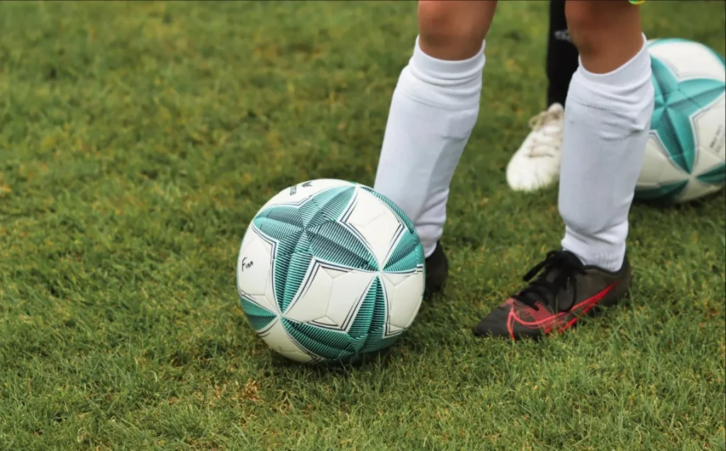 close shot on football and young footballer's leg