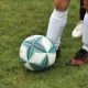 close shot on football and young footballer's leg
