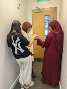 3 girls standing in a corridor laughing