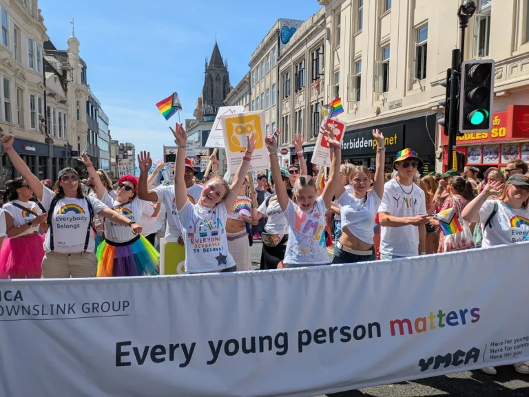 YMCA DownsLink group marching at Brighton Pride 2026, behind a banner reading 'Every young person matters'