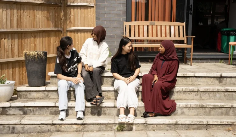 group-of-girls-chattting-in-outdoor-area-in-supported-housing-Guildford