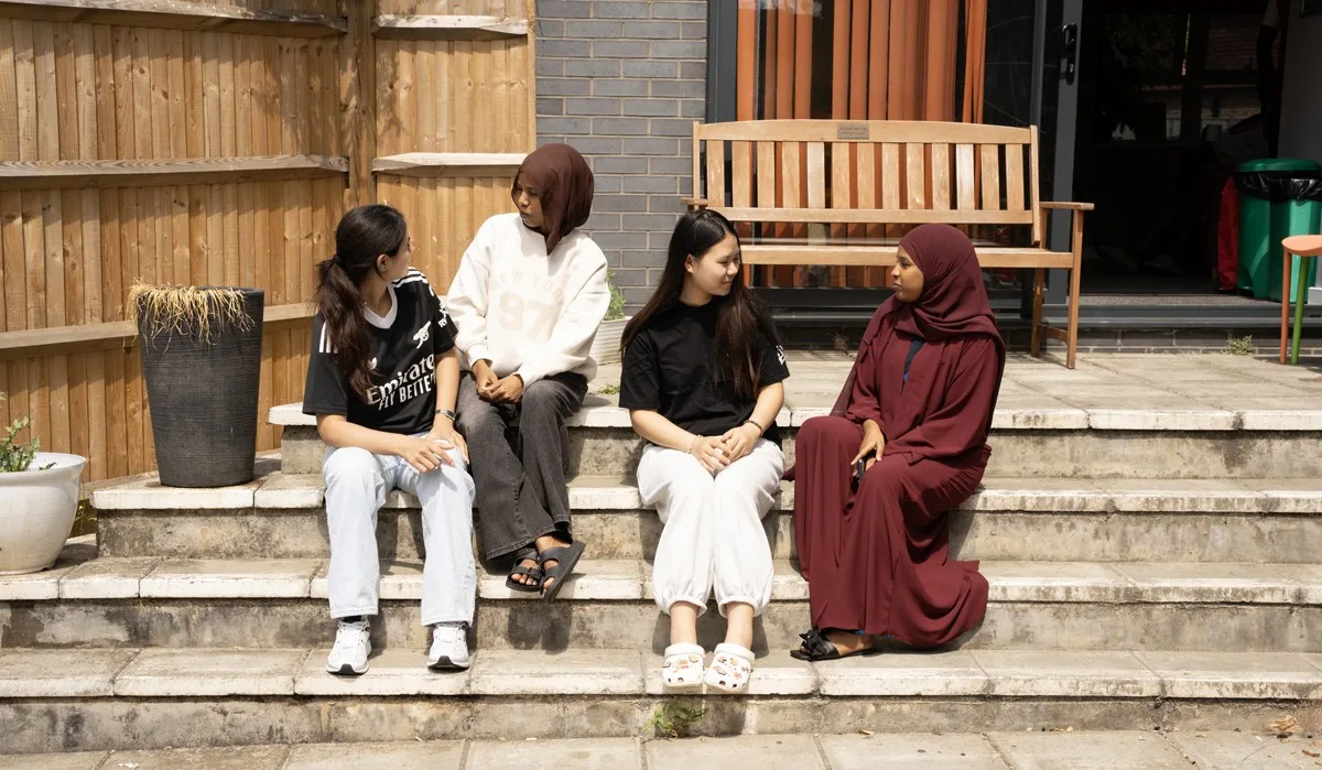 group-of-girls-chattting-in-outdoor-area-in-supported-housing-Guildford