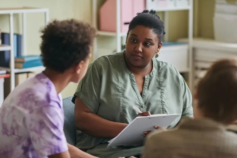 adult with clipboard facing two children seen from back