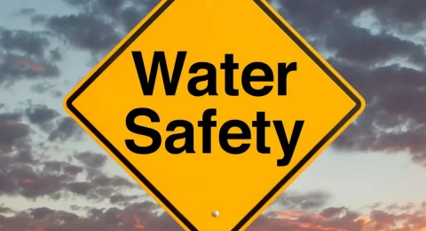 water safety sign against dramatic sky backdrop