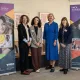 four women stood in front of YMCA DownsLink Group branded banners