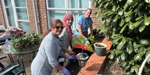 3 women working on the raised planters - websize