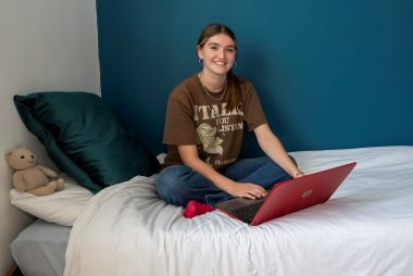 Room sponsorship - Becky sat on bed