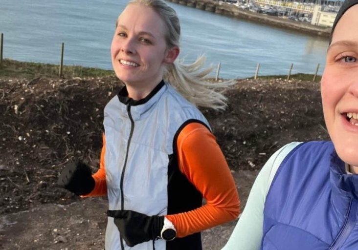 two women running along the seafront selfie