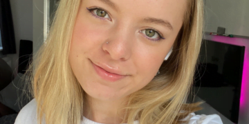 MicrosoftTeams-image (73) Mollie wearing a white shirt smiling taking a selfie