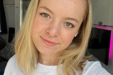 Mollie wearing a white shirt smiling taking a selfie