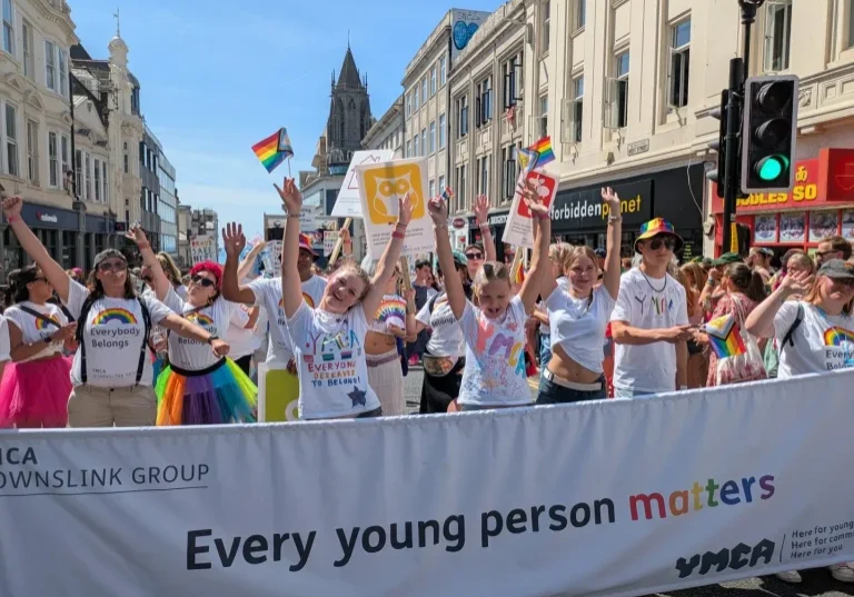 YMCA DownsLink group marching at Brighton Pride 2026, behind a banner reading 'Every young person matters'