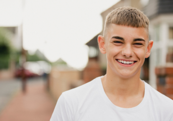 Young man archie smiling on a street