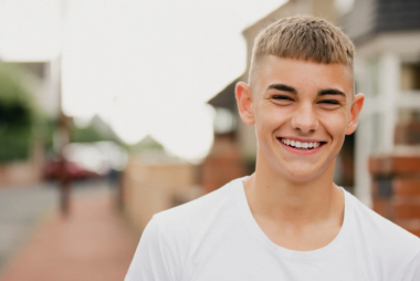 Young man archie smiling on a street