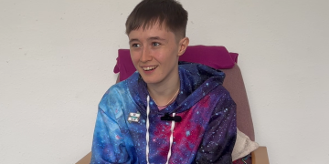 Vivian photo_Brighton Youth Advice Centre Vivian smiling, wearing a space patterned hoodie