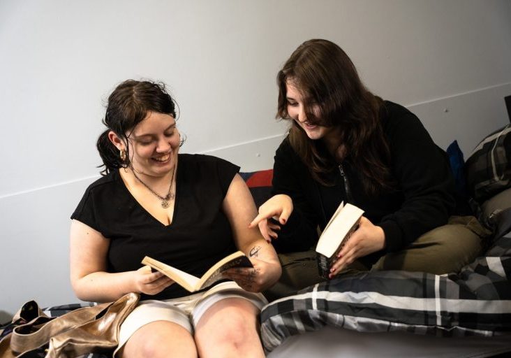 tenant satisfaction featured image. two girls sat on a bed reading together