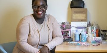 Mapalo sat at a desk smiling at he camera