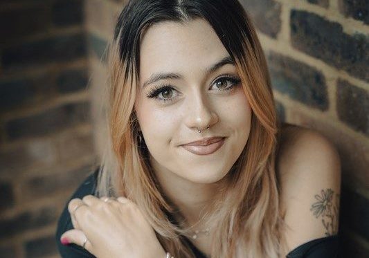 Young woman with brick wall background