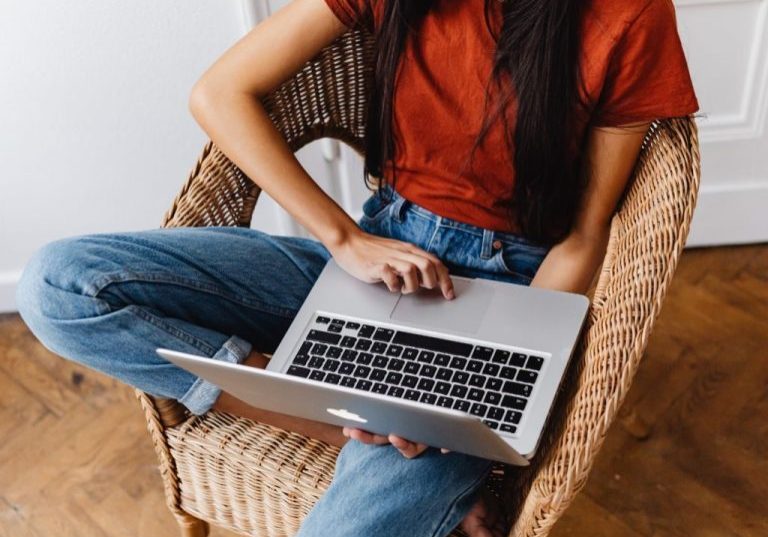 young woman on laptop, head not visible