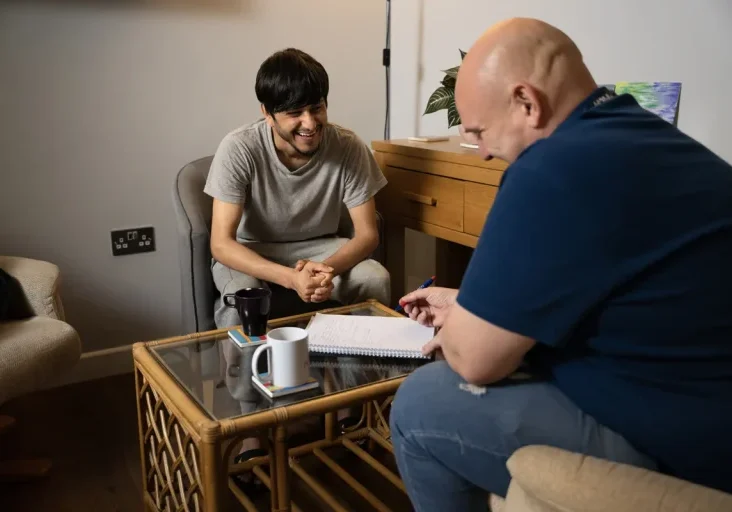 young man and adult name chatting around coffee