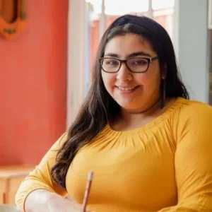 Young woman with long hair and glasses, depicting YMCA DLG young person "Layla"