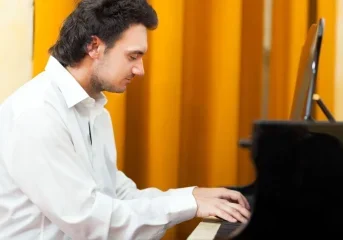 young man playing the piano in profile